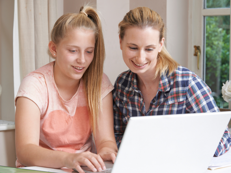 Mom and daughter busy with online tutoring.